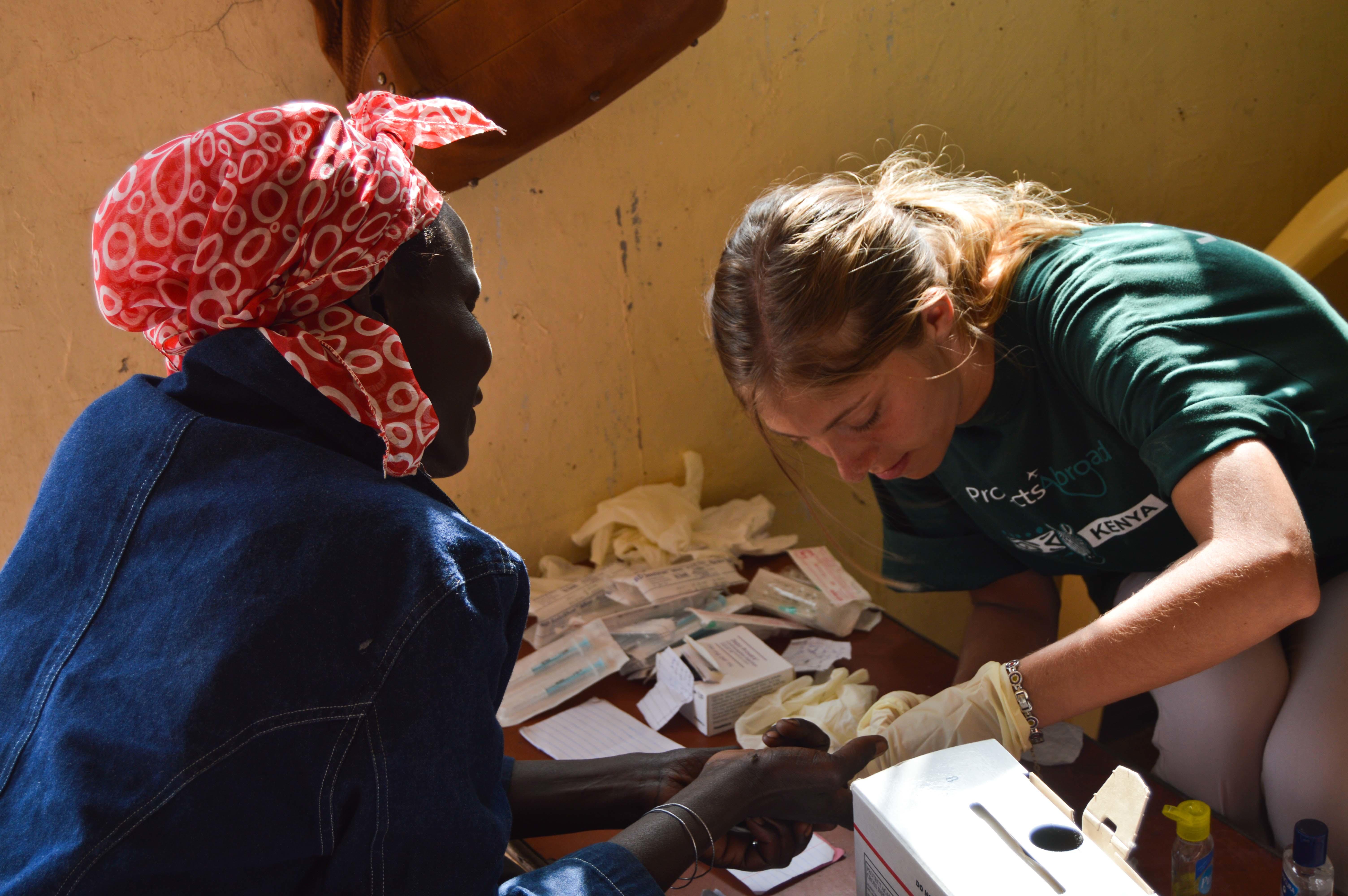 Projects Abroad Female intern treats local womans foot at a medical outreach centre during Medical internship in Kenya. Female Medical intern treats a hand wound on a local woman during a Medical Outreach programme in Kenya.